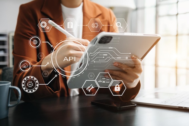 API Application Programming Interface vrouw die een laptop, tablet en smartphone gebruikt met een virtueel scherm API-pictogram Software-ontwikkelingstool moderne technologie en netwerkconcept