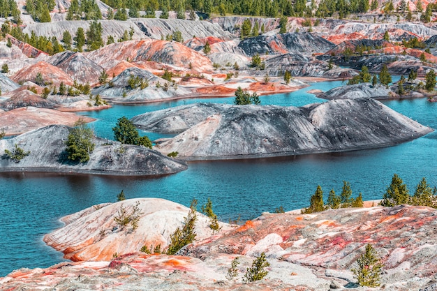 Apocalyptic landscape like a planet Mars surface. Fantastic view of blue lake. Solidified red-brown black Earth surface. Barren, cracked and scorched land. Global warming concept