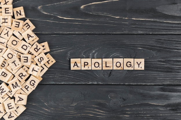 Photo apology word on wooden background