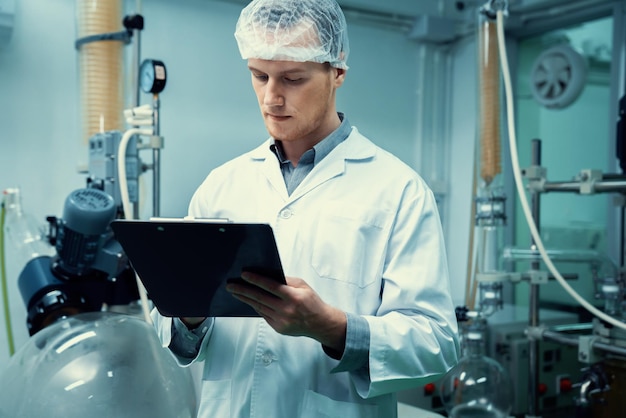 Apothecary scientist recording information from a CBD oil extractor