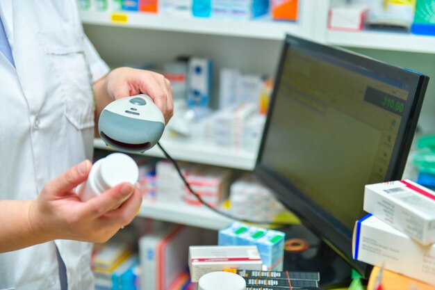 Apotheker die streepjescode van geneeskundedrug aftasten in een apotheekdrogisterij.