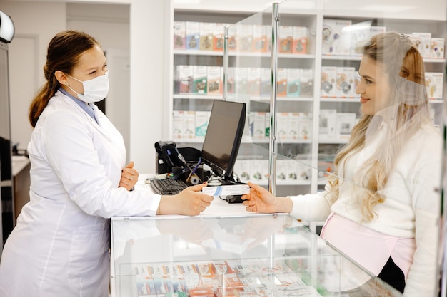 apotheker verkoopt medicijnen een vrouw koopt medicijnen bij de apotheek