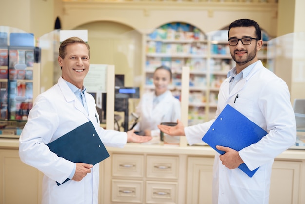 Apothekers staan in de apotheek en houden de map vast.