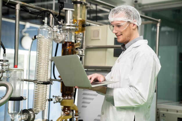 Foto apothekerwetenschapper die gegevens opneemt van cbd-olie-extractor in laboratorium