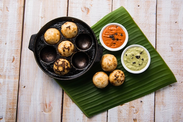 AppamまたはMixeddalまたはRavaAppeは、緑と赤のチャツネを添えた不機嫌そうな背景の上で提供されます。ボールの形で人気の南インドの朝食レシピ。セレクティブフォーカス
