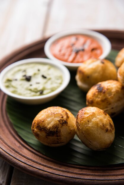 Appam of Mixed dal of Rava Appe geserveerd op een humeurige achtergrond met groene en rode chutney. Een populair Zuid-Indiaas ontbijtrecept in de vorm van een bal. Selectieve focus