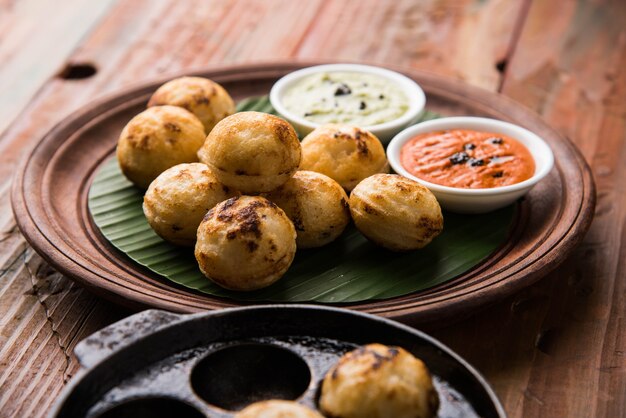 Appam of Mixed dal of Rava Appe geserveerd op een humeurige achtergrond met groene en rode chutney. Een populair Zuid-Indiaas ontbijtrecept in de vorm van een bal. Selectieve focus