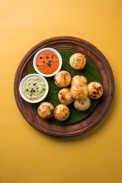 Appam of Mixed dal of Rava Appe geserveerd op een humeurige achtergrond met groene en rode chutney. Een populair Zuid-Indiaas ontbijtrecept in de vorm van een bal. Selectieve focus