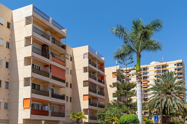 Appartementengebouw met palmbomen en een bord voor appartementen op de achtergrond
