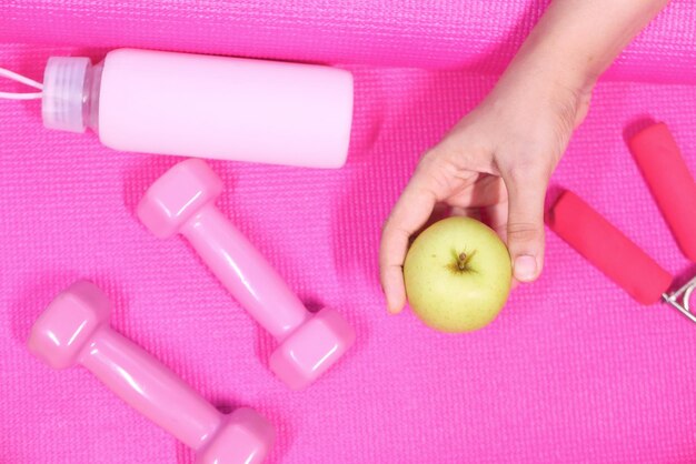 appel roze kleur dumbbell water fles op oefenmat