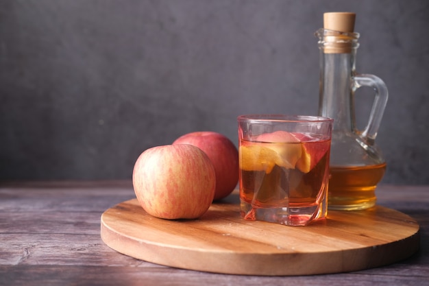 Appelazijn in glazen fles met verse groene appel op tafel