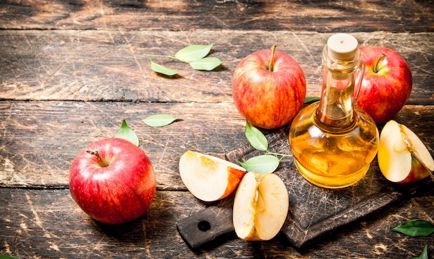 Appelazijn, rode appels op houten tafel.