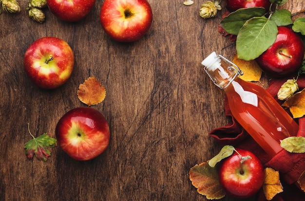 Appelciderazijn Fles verse biologische appelazijn op houten tafel achtergrond met kaneelstokjes anijs sternoten en gevallen bladeren Gezonde biologische voeding Kopieer ruimte