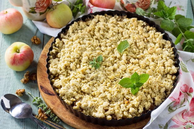 Appels crumble knapperig in ovenschaal op houten tafel