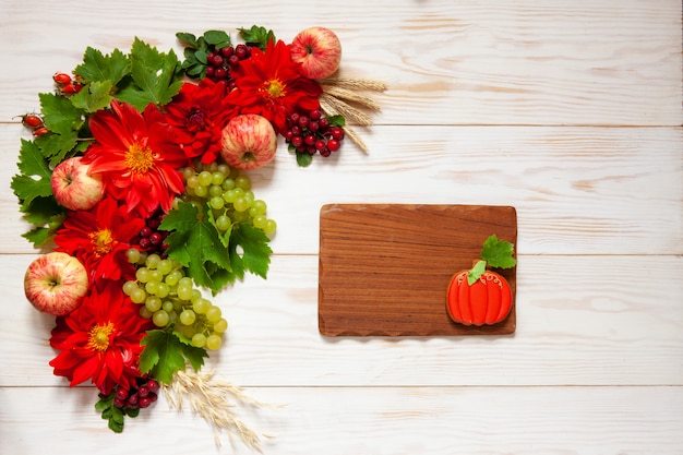 Appels, druiven, rode dahlia bloemen, rode lijsterbessen en honing met kopie ruimte