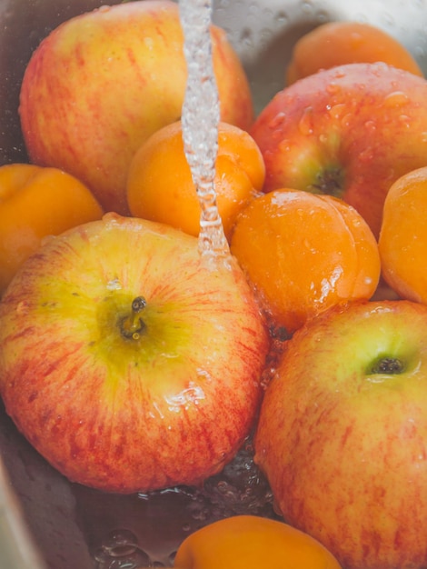 Appels en perziken worden gewassen in de gootsteen.