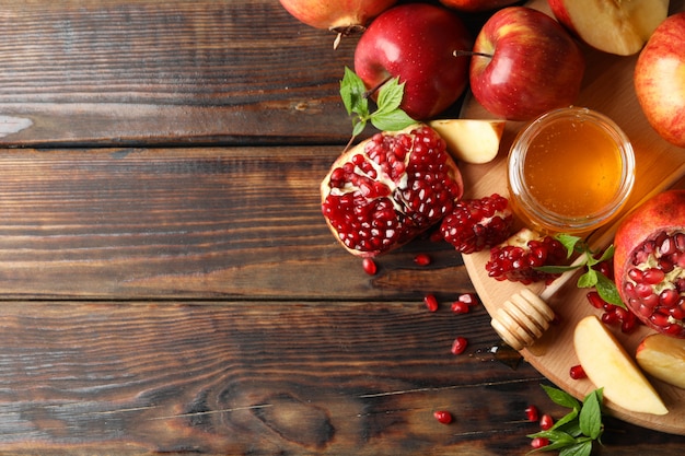 Appels, granaatappel en honing op houten, bovenaanzicht