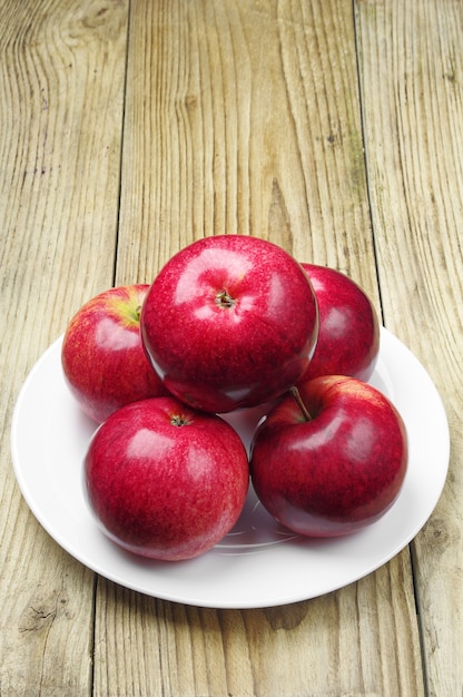 Appels in een bord op een houten ondergrond