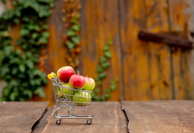 Appels in kleine kar op houten bureau in een tuin