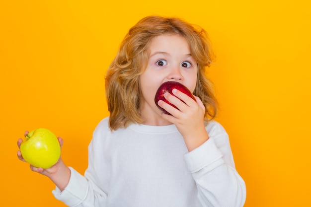 Appels Kind met appel in studio Studio portret van schattig kind greep appel geïsoleerd op gele achtergrond