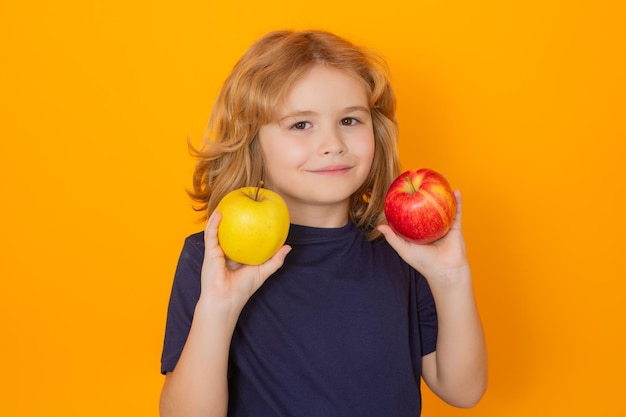 Appels Kind met appel in studio Studio portret van schattig kind greep appel geïsoleerd op gele achtergrond