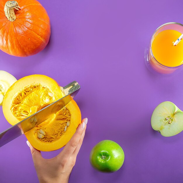 Appels, pompoenen en sap op paars, bovenaanzicht