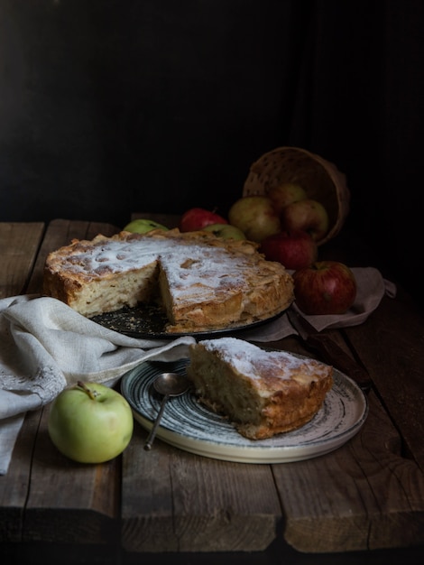 Appeltaart en appels op een houten tafel