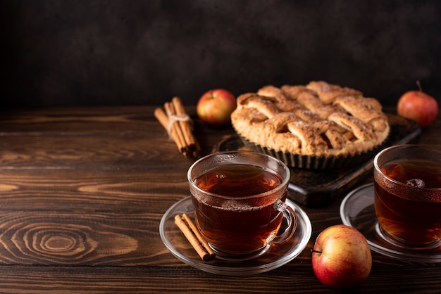 Appeltaart met kaneel en hete zwarte thee op een houten tafel