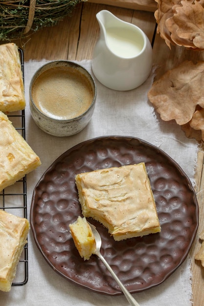 Appeltaart plakjes met meringue geserveerd met koffie. Rustieke stijl.