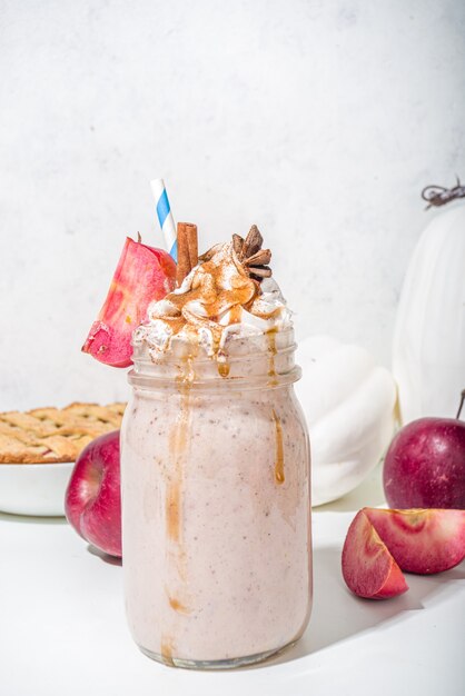 Appeltaart-smoothie. Crazy shake-cocktail met traditionele herfstappel-pecannootsmaak, witte achtergrondkopieruimte