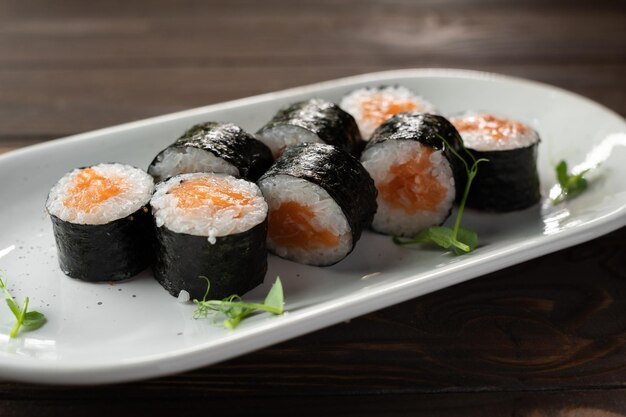 Appetiserende sushi rol futomaki met zalm op een wit bord Sushi menu
