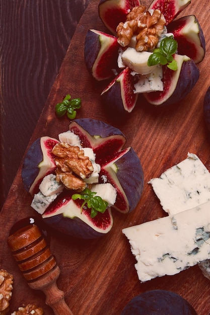Appetizer Figs with blue cheese walnut honey on a wooden board top view closeup no people