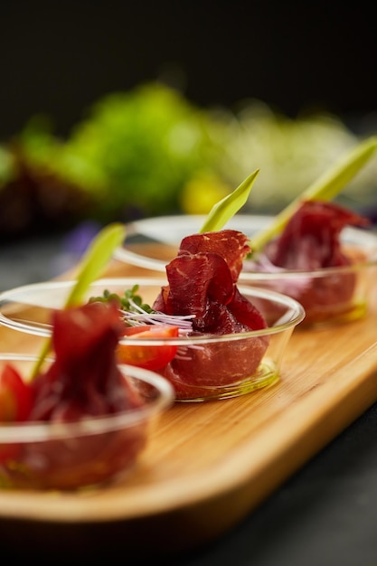 Appetizer from dry cured ham prosciutto slices on a dark background Photo for restaurant menu