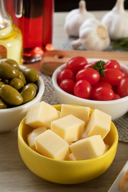 Appetizer jars with cheese, olives and cherry tomatoes.