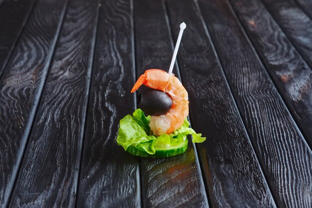 Appetizer for reception. Slice of cucumber with shrimp and olive on skewer