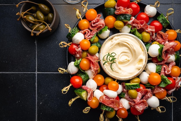 Foto set di aperitivi e rinfreschi piatto di canapè con verdure formaggio salami e olive decorato per la tavola da festa vista dall'alto