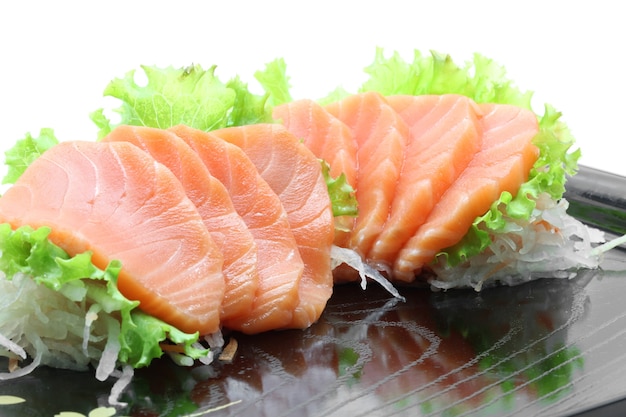 Photo appetizer salmon sashimi on black dish with reflection