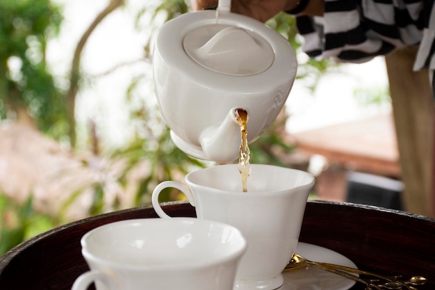 Набор закусок и чашек для чая для путешественников и гостей на обеденной террасе под открытым небом ресторана в курортном отеле в Таиланде