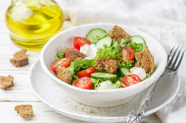 Appetizer of tomatoes, cucumbers, lettuce, mozzarella and bread