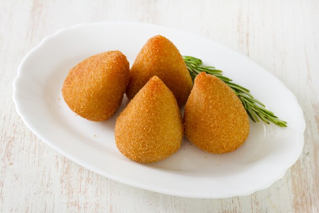 Appetizer on white plate on white wooden surface