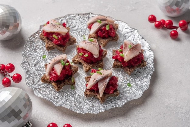 Appetizer with herring fillet with beetroot onion and black bread