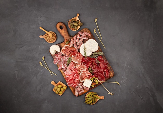 Tavolo per aperitivi con diversi antipasti, salumi, snack e vino