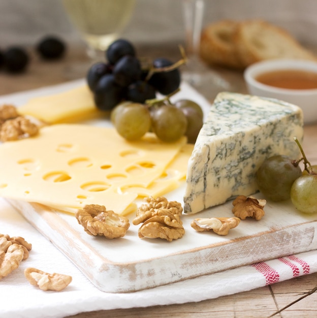 Appetizers of various types of cheese, grapes, nuts and honey, served with white and red wine