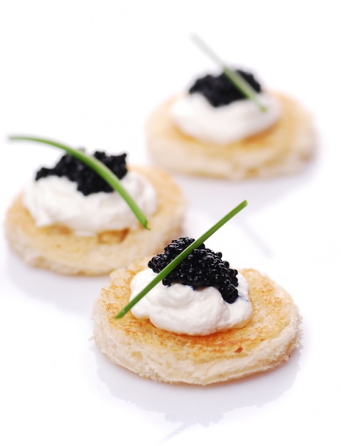 Appetizers with caviar on white