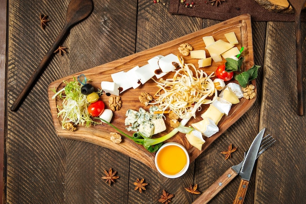 Foto antipasti con formaggio sulla tavola di legno