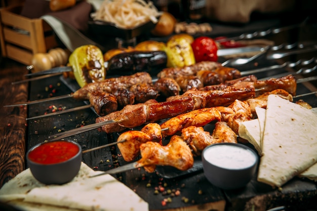 Appetizing assorted set of kebab skewers on a dark wooden surface