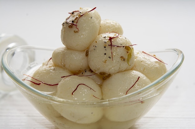 Appetizing ball-shaped dumplings of Rasagulla dessert in light sugar syrup