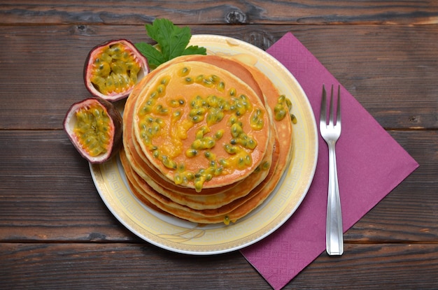 Appetizing breakfast pancakes with passion fruit top view