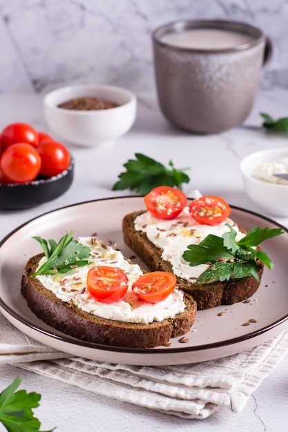 Appetizing bruschetta with ricotta tomatoes flax seeds and parsley on a plate Vertical view