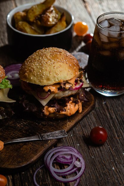 Фото Аппетитный бургер с куриной котлетой на деревянной доске